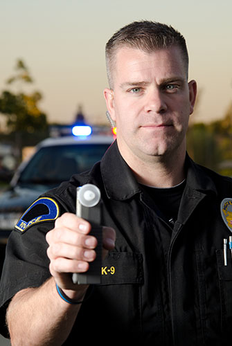 Police Officer holding a breathalyzer for DUI